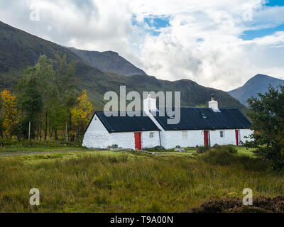 White Lavata stone Black Rock Cottage capanna di arrampicata in Glen Coe con Stob Dhearg di Buachaille Etive Mor mountain range in background nel Scotti Foto Stock