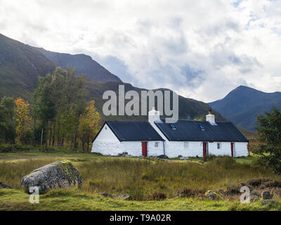 White Lavata stone Black Rock Cottage capanna di arrampicata in Glen Coe con Stob Dhearg di Buachaille Etive Mor mountain range in background nel Scotti Foto Stock