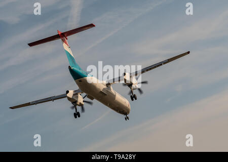 London, Regno Unito - 17 Febbraio 2019: Luxair Lussemburgo una compagnia aerea regionale con sede in Lussemburgo, il tipo di aereo De Havilland Canada DHC-8-400 volare sul cielo blu Foto Stock