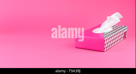 Tovaglioli di carta in un riquadro rosa su uno sfondo semplice. Spazio libero per il testo. Spazio di copia Foto Stock