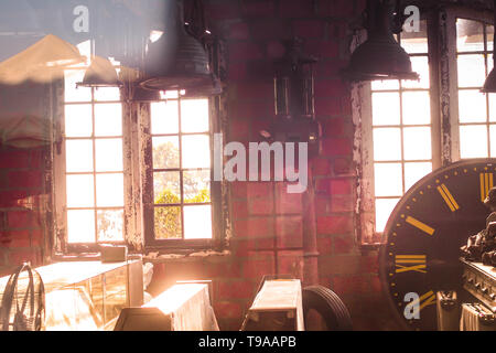 La luce del sole che splende attraverso le finestre di un vecchio capannone industriale abbandonato edificio. vintage loft idea dello sfondo. Foto Stock