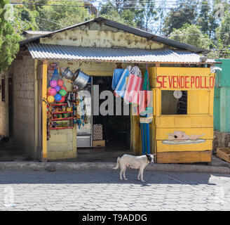 Festivo negozio di fronte con un cane e strada acciottolata, a San Marcos, Lago Atitlan, Guatemala Foto Stock