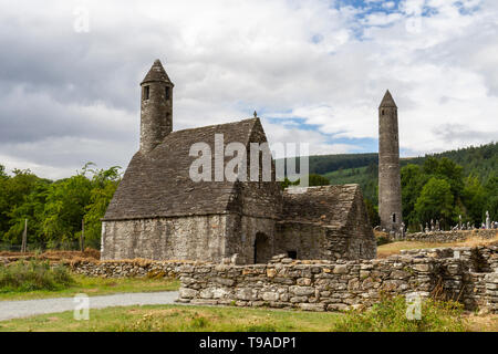 San Kevin la chiesa con il Glendalough Roundtower a Glendalough, County Wicklow, Irlanda. Foto Stock