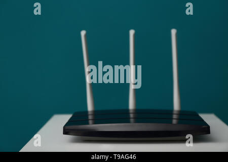 Moderni router wi-fi sul tavolo luminoso contro il colore di sfondo Foto Stock