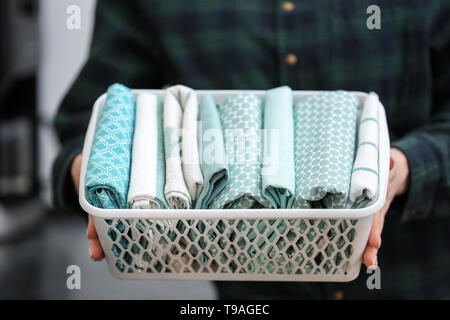 Donna cestello di contenimento con pulire gli asciugatutto da cucina, primo piano Foto Stock