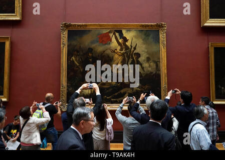 Pechino, Francia. 15 Maggio, 2019. La gente a prendere le foto di La Liberte guidant le peuple, o la libertà di guidare il popolo, da Eugene Delacroix visualizzati al museo del Louvre a Parigi, Francia, 15 maggio 2019. Sabato segna la Giornata Internazionale dei Musei. Credito: Alexandre Karmen/Xinhua/Alamy Live News Foto Stock