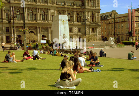 Glasgow, Scotland, Regno Unito, 17 maggio 2019, UK Meteo. Sunny scorcher di un giorno per la gente del posto e i turisti condividono l'erba con i piccioni nel centro civico della città George Square. Credito traghetto Gerard/Alamy Live News Foto Stock