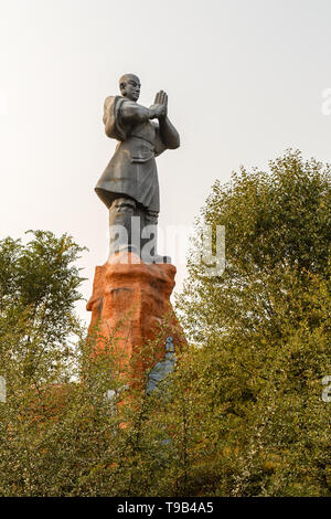 Dengfeng, Cina - 17 Ottobre 2018: Statua di un monaco guerriero saluto tutti all'ingresso al monastero Shaolin. Foto Stock