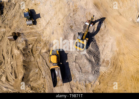 Carrello industriale escavatore caricatore movimento della terra e di scarico. Vista aerea Foto Stock