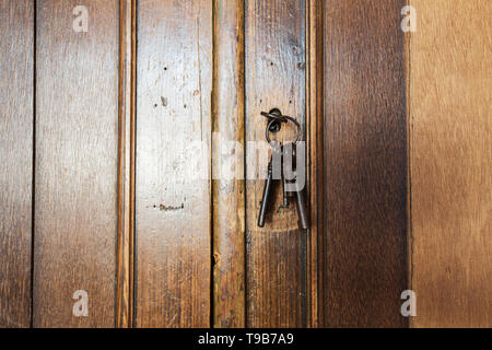 Vecchio arrugginito chiavi all'interno di una toppa di un antico armadio. design vintage Foto Stock