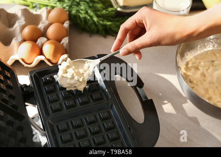 La donna la preparazione di cialde in moderno maker Foto Stock