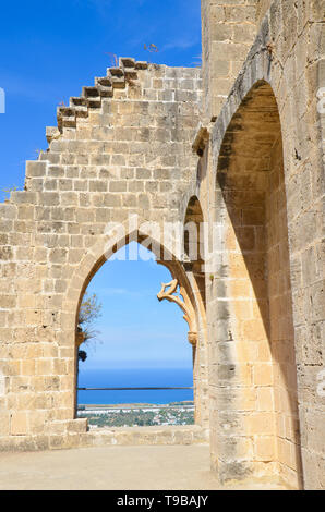 Resti delle mura del centro storico di Bellapais Abbey con una finestra che offre una splendida vista di Kyrenia cipriota regione. Vista popolari Foto Stock