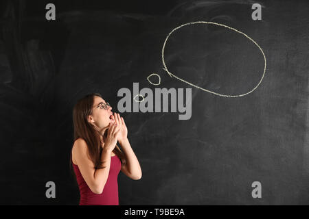 Giovane donna vicino a vuoto discorso bolla disegnato sulla lavagna Foto Stock