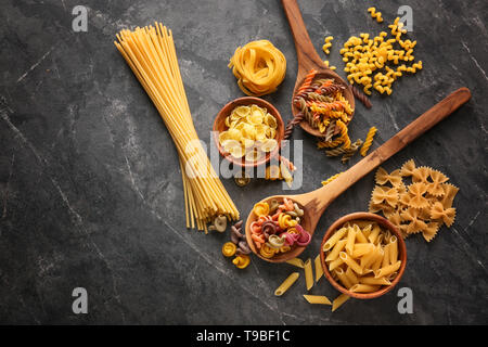 Diversi tipi di pasta su uno sfondo grigio Foto Stock