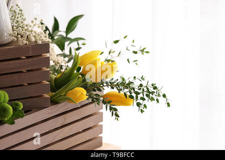 Cassa con bellissimi tulipani e rami di eucalipto, primo piano Foto Stock