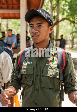 Isola di Komodo, Indonesia - 24 Febbraio 2019: Parco Nazionale di Komodo. Ritratto di giovane uomo in verde scuro abito è un ranger, guida nel parco. Foto Stock