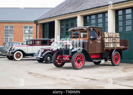 Vintage camion e auto al di fuori di un garage a Bicester Heritage Centre 'Drive giorno'. Bicester, Oxfordshire, Inghilterra. Foto Stock