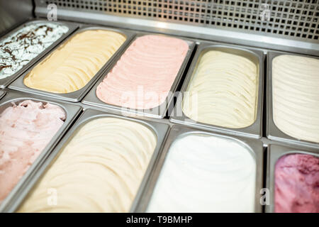 Vassoi di metallo piena di colorati gelato nella vetrina frigorifero Foto Stock