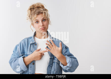 Sconvolto cupo piuttosto scandinavian blonde curly-ragazza dai capelli blu-eyed accigliata sentirsi giù infelice di alzare la mano mostra anello dito deluso ancora single Foto Stock