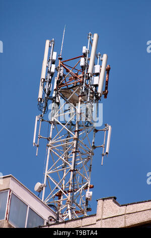 Telecomunicazioni stazioni base di ripetitori di rete sul tetto dell'edificio. La comunicazione cellulare Antenna sul city building tetto. Foto Stock