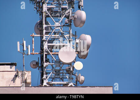 Telecomunicazioni stazioni base di ripetitori di rete sul tetto dell'edificio. La comunicazione cellulare Antenna sul city building tetto. Foto Stock