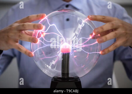 Close-up di Fortune Teller tenendo in mano i incandescente sfera di cristallo Foto Stock