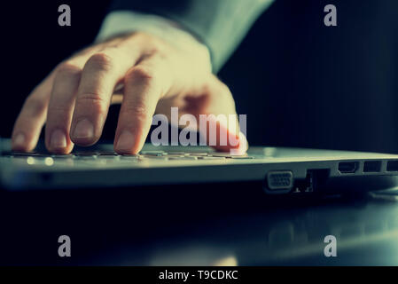 Primo piano delle mani di un uomo digitando su un computer. Con retro effetto del filtro. Foto Stock