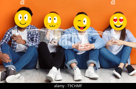 Gli adolescenti con positivi gli Emoji icone smartphone utilizzando Foto Stock