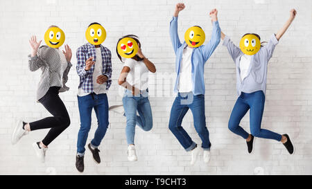 Amici facce ricoperte con le emoticon su sfondo bianco Foto Stock