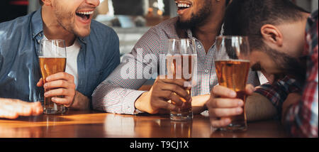 Celebrare la riunione. Diversi amici a bere birra e ridere Foto Stock