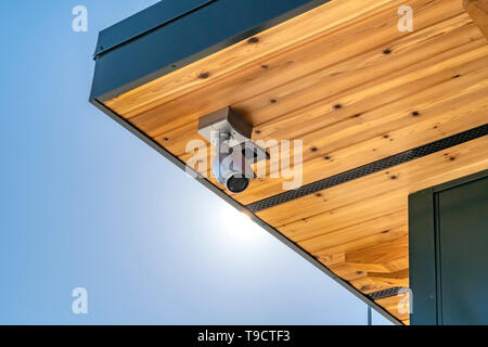 Home con una telecamera di sicurezza installate sul lato inferiore di legno del tetto Foto Stock