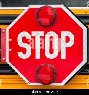 Cancellare Square Close up di un ottagono rosso a forma di stop con luci di segnale su un bus di scuola Foto Stock