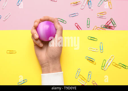 Mano femmina con palla e le fascette sul colore di sfondo Foto Stock