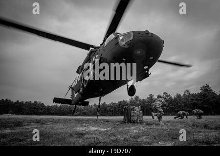 Stati Uniti Esercito Nazionale soldati di guardia dal New Jersey 250ª Brigata Battaglione di supporto eseguire dopo l'aggancio fino al carico di un UH-60M Black Hawk elicottero dal primo elicottero d'assalto battaglione, 150° Reggimento di aviazione durante il carico di imbracatura training su base comuneGuire-Dix Mc-Lakehurst, N.J., 4 maggio 2019. (U.S. Air National Guard foto di Master Sgt. Matt Hecht) Foto Stock