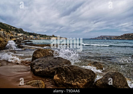 Andiamo alla spiaggia. Una vista della spiaggia, il mare e le sue coste in Gnejna Bay, Malta. Foto Stock