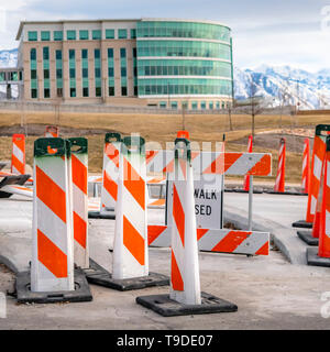 Quadrata trasparente chiusa sul marciapiede segno e la sicurezza stradale poli su una strada pavimentata in riparazione Foto Stock