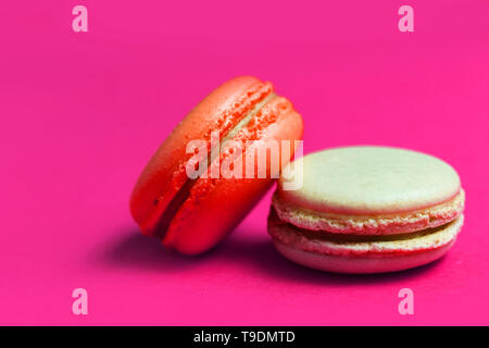 Primo piano di colore arancione e beige amaretto torta su sfondo rosa, spazio di copia Foto Stock