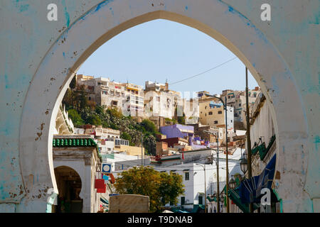 La collina con le case e le strade di moulay idriss zerhoun in una giornata di sole, visto attraverso il cancello di ingresso della città, Marocco. Foto Stock