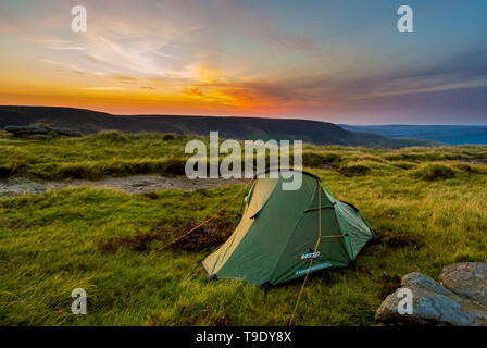 Campeggio selvaggio. Piccola tenda nel deserto di sunrise. Il Peak District, UK. Foto Stock