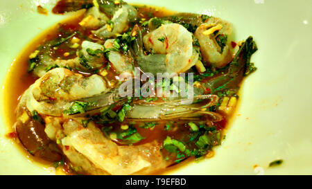 Gamberi freschi serviti su un piatto con insalata mista condita con salsa di soia che mostra colori vivaci e ingredienti freschi per la cucina a base di pesce Foto Stock