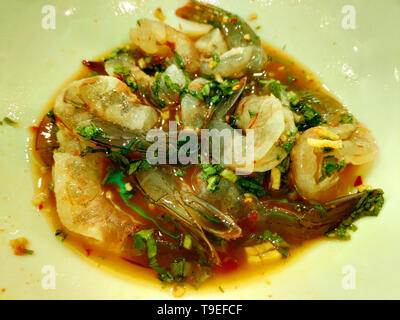 Gamberi freschi serviti su un piatto con insalata mista condita con salsa di soia che mostra colori vivaci e ingredienti freschi per la cucina a base di pesce Foto Stock