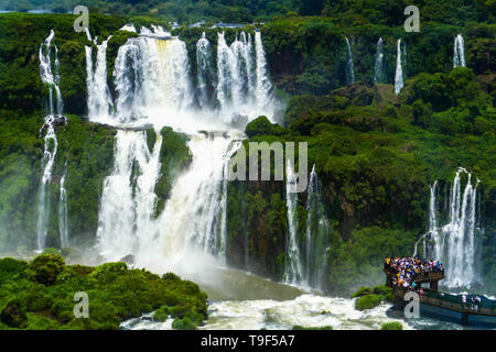 I turisti a Iguazu Falls, uno dei piu' grandi meraviglie naturali del mondo, sul confine del Brasile e Argentina. Foto Stock