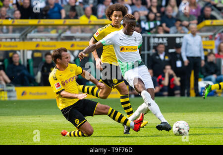 18 maggio 2019, Renania settentrionale-Vestfalia, Mönchengladbach: Calcio - Bundesliga, Borussia Mönchengladbach - Borussia Dortmund, trentaquattresima Giornata in Borussia Park. Dortmund's Mario Götze (l) cerca di ostacolare Gladbach's Denis Zakaria durante lo shot. Dortmund Axel Witsel (M) segue la scena. Foto: Guido Kirchner/dpa - NOTA IMPORTANTE: In conformità con i requisiti del DFL Deutsche Fußball Liga o la DFB Deutscher Fußball-Bund, è vietato utilizzare o hanno utilizzato fotografie scattate allo stadio e/o la partita in forma di sequenza di immagini e/o video-come sequenze di foto. Credito: dpa pi Foto Stock