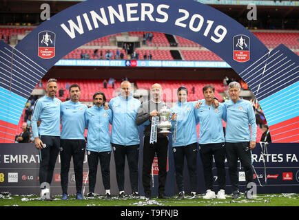 Manchester City manager Pep Guardiola (centro) celebra con il trofeo dopo aver vinto la finale di FA Cup con il coaching personale (da sinistra a destra) Richard Wright, Xabi Mancisidor, Lorenzo Buenaventura, Rodolfo Borrell, Mikel ARTETA, Carles Planchart e Brian Kidd durante la finale di FA Cup a Wembley, Londra. Foto Stock