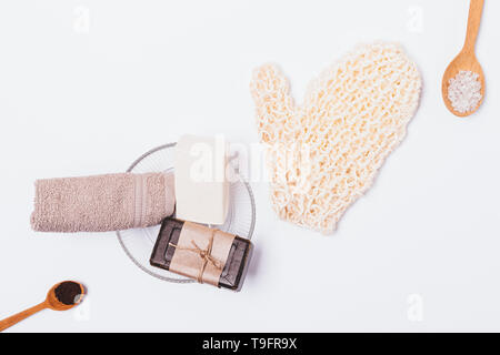 Vista da sopra la composizione di prodotti di bellezza e accessori per la pulizia ed esfoliazione della pelle del corpo, disposizione piatta su sfondo bianco. Foto Stock