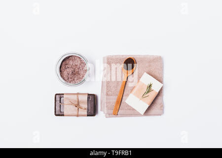 Vista da sopra il caffè naturale cosmetici per la pulizia e la spugnetta esfoliante per la pelle a casa. Sapone organico, macchia di caffè macinato e sale marino con rosmarino o Foto Stock