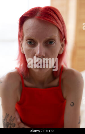 Skinny donna con tatuaggi sentirsi soli e miserabili Foto Stock