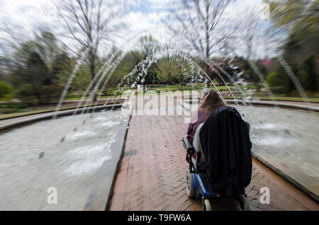 Equitazione donna Scooter attraverso un tunnel Fontana Foto Stock