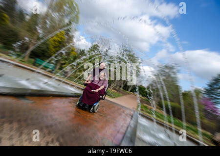 Equitazione donna Scooter attraverso un tunnel Fontana Foto Stock
