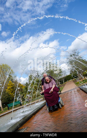 Equitazione donna Scooter attraverso un tunnel Fontana Foto Stock